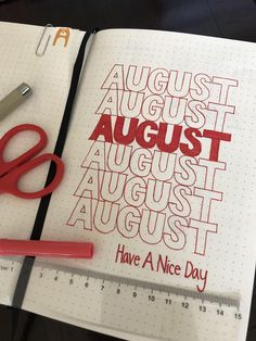 an open notebook with red lettering on it next to a pair of scissors and a ruler