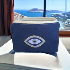 "Blue Evil Eye Pouch - Evil Eye accessory - Greek Souvenir - Gift for her Perfect to store small things. Material : - Outside fabric is made of blue cotton fabric  with an embroidery evil eye design.  The embroidered design measures about 8 x 5 cm - 3.15\" x 1.95\" inches - Lining is made of ecru cotton fabric - Ecru zipper - Size is 19x14cm - 7.5 \" x 5.5\" - Due to handmade, size may vary by +/- 1 cm" Blue Cosmetic Pouch Bag For Personal Use, Blue Pouch As Gift Bag, Blue Pouch For Gift, Handmade Blue Rectangular Pouch, Blue Bag With Zipper Pouch As Gift, Handmade Cotton Rectangular Pouch, Blue Rectangular Pouch For Personal Use, Handmade Blue Cosmetic Bag For Gift, Canvas Cosmetic Pouch As Gift