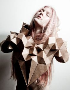 a woman with pink hair is wearing an origami sculpture