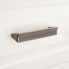 a close up of a metal door handle on a white painted wall with horizontal stripes