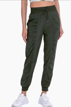 These flattering lightweight woven olive joggers are ideal for any indoor or outdoor adventure! Enjoy the convenient adjustable drawstring waist, ribbed hem and waistband, ruched front detailing, roomy side pockets, and a ribbed rear yoke for max mobility and comfort.Shell: 94% polyester 6% spandexRib: 100% polyester27" inseamColor- Olive Green Sporty Stretch Cargo Pants With Functional Drawstring, Sporty Stretch Cargo Pants With Drawstring, Solid Color Sporty Joggers With Drawstring, Relaxed Fit Utility Joggers With Drawstring, Sporty Spring Joggers With Drawstring, Sporty Green Joggers For Outdoor Activities, Utility Style Relaxed Fit Joggers With Drawstring, Sporty Drawstring Joggers For Spring, Solid Nylon Joggers With Elastic Waistband