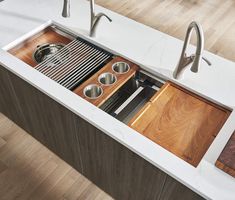 a kitchen sink with wooden counter tops and stainless steel faucets