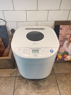 a white bread maker sitting on top of a kitchen counter next to a cookbook