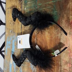 two black headbands with fur on them sitting on a wooden table next to a card