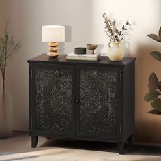 a black cabinet sitting next to a lamp on top of a table