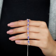 Product Details Express your love to your loved one on Valentines Day by presenting this Tanzanite Link Bolo East West Bracelet. This Tanzanite Bracelet is perfectly adorned with Oval Cut Tanzanite in Prong Setting. Product Information SKU SHP-BRACELET0621104597 Length 177.8 mm Width 4 mm Height 2.5 mm Weight 6.30 gm (Approximate) TANZANITE INFORMATION No.of Stones 9 Pieces Total Weight 4.86 Carat (Approximate) Dimension(approx) Oval-4X6 mm-9 Pcs Color Blue Cut Brilliant Shape Oval Setting Type Cubic Zirconia Jewelry With Handset Stones As Gift, Handset Stones Bracelet Jewelry Gift, Handset Stones Bracelet Jewelry For Gift, Purple Tennis Bracelet For Anniversary, Diamond Bracelet With Handset Stones For Anniversary, Bracelets With Handset Stones, Round Shape, As Gift, Silver Jewelry With Handset Stones For Gift, Round Bracelets With Handset Stones For Gift, Handset Stones Bracelets With Round Shape As Gift