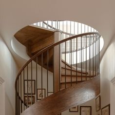 a spiral staircase in a home with pictures on the wall