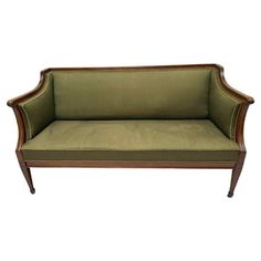 a green couch sitting on top of a wooden frame