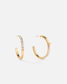 Slim lines and glittering stones give these hoop earrings a surprising dose of effortless glamor and contemporary luxury, fashioned into a subversive-basic design. Keep it casual and cool with a pair of classic hoops upgraded for your modern lifestyle.
 
Size: 3×33mm
Stone Color: Shiny White
Material: Crystals, 18k Gold Plated On Brass Sparkling Stones Hoop Earrings, Modern Small Hoop Earrings With Diamond Accents, Everyday Hoop Earrings With Sparkling Stones, Modern Hoop Earrings With Sparkling Stones, Minimalist Hoop Earrings With Diamond Accents, Elegant Hoop Earrings With Sparkling Stones For Everyday, Sparkling Hoop Earrings For Everyday, Elegant Everyday Hoop Earrings With Sparkling Stones, Everyday Elegant Hoop Earrings With Sparkling Stones