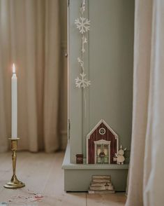 a candle is lit next to a small house