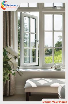 a white bench sitting in front of a window next to a vase filled with flowers