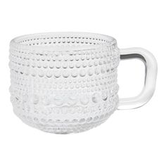 a white glass cup with a handle on it's side, sitting on a white surface