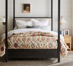 a bedroom with a four poster bed and pillows on the covers, along with two nightstands