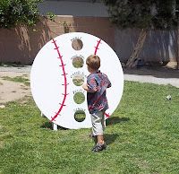 a young boy standing in front of a giant baseball shaped paper plate on the grass