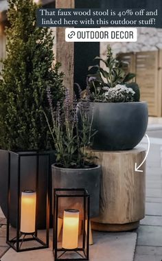 some plants and candles are sitting on the ground next to a sign that says outdoor decor