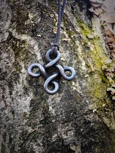 a metal knot is hanging on a tree