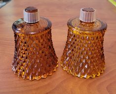 two brown glass bottles sitting on top of a wooden table