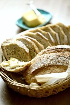 sliced bread in a basket with butter on the side