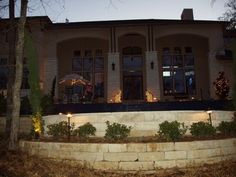 a house that is lit up at night with christmas lights on the front and side