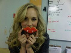 a woman holding a fake red lips in front of her face