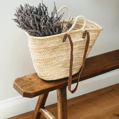 a wicker basket sitting on top of a wooden bench