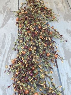 an arrangement of berries and leaves on a wooden surface