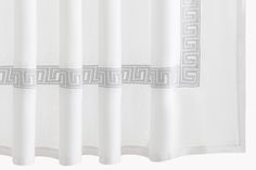 a white shower curtain with grey greek border