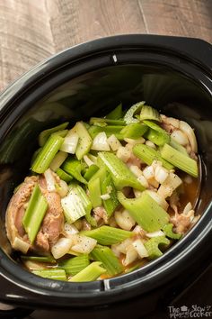 a slow cooker filled with meat and vegetables