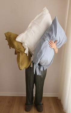 a person holding two pillows in their hands