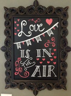 a chalkboard sign that says love is in the air