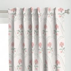 a curtain with pink flowers on it hanging from a window sill in front of a white wall