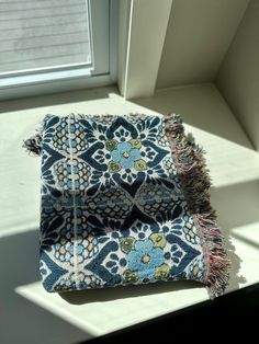 three pieces of cloth sitting on top of a window sill