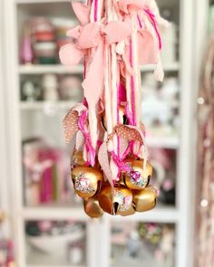 a pink and gold wind chime hanging from a window