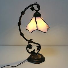 a lamp that is sitting on top of a table with a light bulb in the shape of a flower