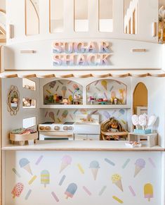 a small ice cream shop with lots of decorations on the wall and shelves in front of it