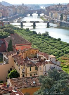 an aerial view of the city and river in italy, with bridges crossing over it