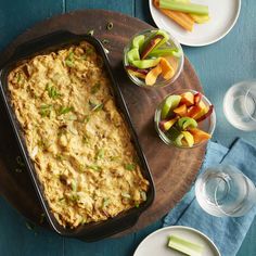 a casserole dish with carrots, celery and apples on the side