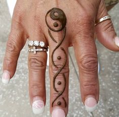 a woman's hand with hennap and ring tattoos on her left hand