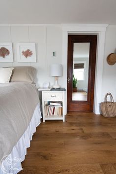 a bedroom with wood floors and white walls