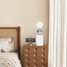 a bedroom with a bed, nightstand and clock on the side table next to it