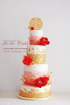 a three tiered wedding cake with red flowers on the top and gold trimmings