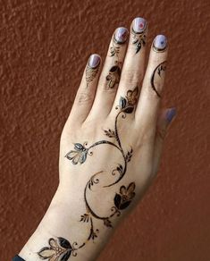 a woman's hand with tattoos on it, and flowers painted on the palm