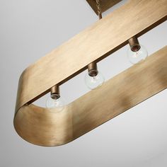 three lights are hanging from the ceiling in this modern light fixture with wood grain finish