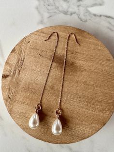 Fine and delicate, these earrings flow from the earlobe in a beautiful rose gold line. These long earrings measure about 5" in length. Hanging from the chains are synthetic pearl teardrop charms. Threader earrings come with wire ends to make it easy to thread the chain through any pierced hole in your ear, making these earrings fun to wear and play around with (from one pierced hole to another). Their versatility is what makes them so popular. They are hypoallergenic and lightweight which makes Elegant Teardrop Threader Earrings As Gift, Elegant Long Drop Threader Earrings As Gift, Dainty Rose Gold Pearl Earrings For Gift, Dainty Rose Gold Pearl Earrings As Gift, Rose Gold Dangle Threader Earrings With Delicate Chain, Rose Gold Dangle Threader Earrings With Adjustable Chain, Rose Gold Delicate Chain Threader Drop Earrings, Rose Gold Adjustable Chain Dangle Threader Earrings, Elegant Rose Gold Threader Earrings With Ear Wire