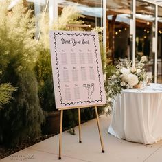 a sign that is sitting on top of a wooden easel next to a table