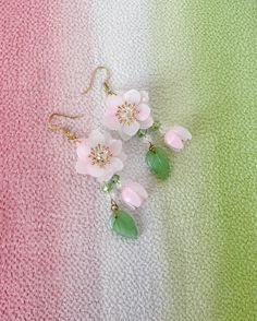 These Cherry Blossom earrings are a delightful addition to any jewelry collection, with their intricate handmade design and delicate pink and white Sakura flowers. The earrings feature a beautiful blend of colors and textures, with flower buds and leaves dangling gracefully from the main flower. The aesthetic earrings are inspired by traditional Japanese style, incorporating the timeless beauty of cherry blossoms into their design. The Kawaii earrings are perfect for anyone who loves cute and ch Cute Flower-shaped Pierced Earrings, Charming Earrings As A Gift, Charming Earrings For Pierced Ears As Gift, Handmade Cute Flower Drop Earrings, Cute Handmade Drop Flower Earrings, Cute Handmade Flower-shaped Earrings, Whimsical Flower Shaped Earrings Gift, Cute Green Flower-shaped Earrings, Handmade Green Kawaii Earrings