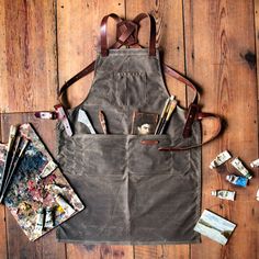 an apron is sitting on the floor with art supplies in it