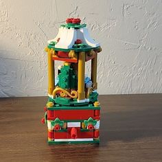 there is a small toy tower on the table with its lights on and it's made out of legos