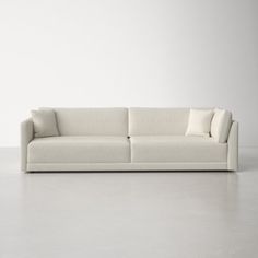 a white couch sitting on top of a cement floor