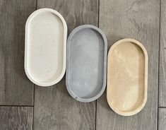 three empty trays sitting on top of a wooden floor